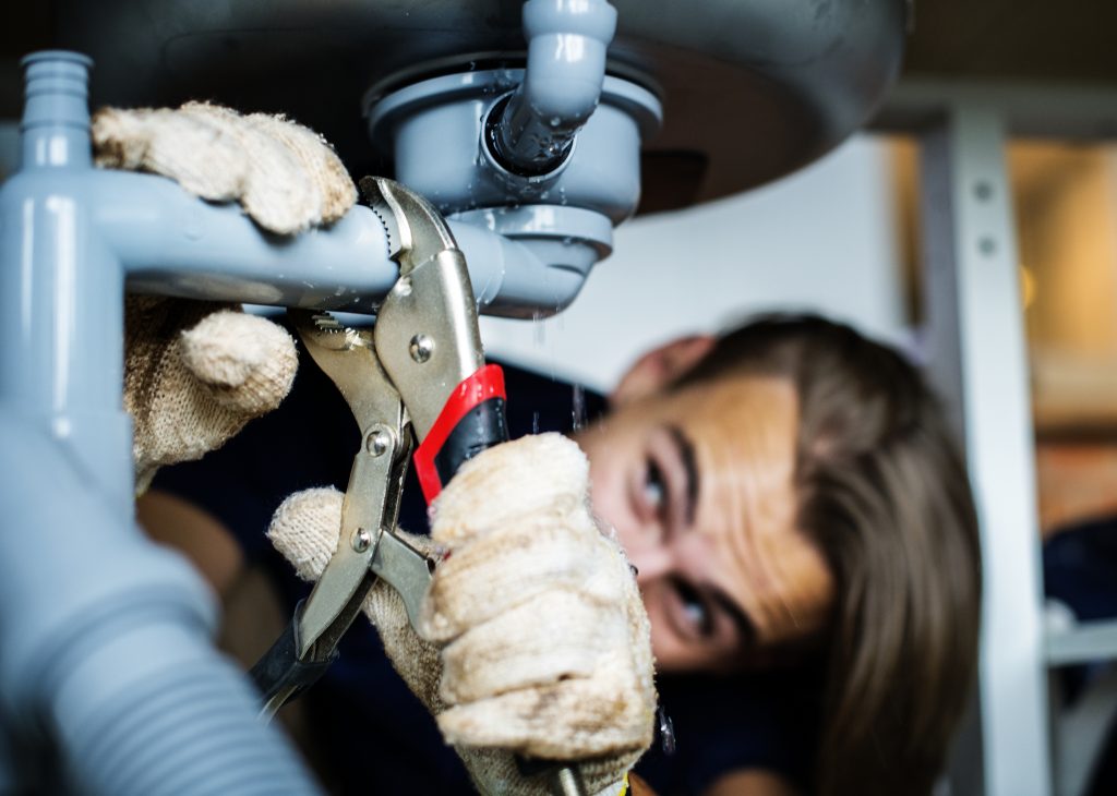 Man fixing kitchen sink for drain cleaning